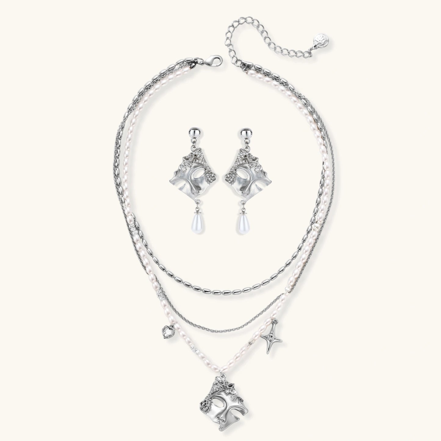 Ornate silver-toned masquerade mask jewelry set featuring rhinestone details and pearl drop earrings on white background.