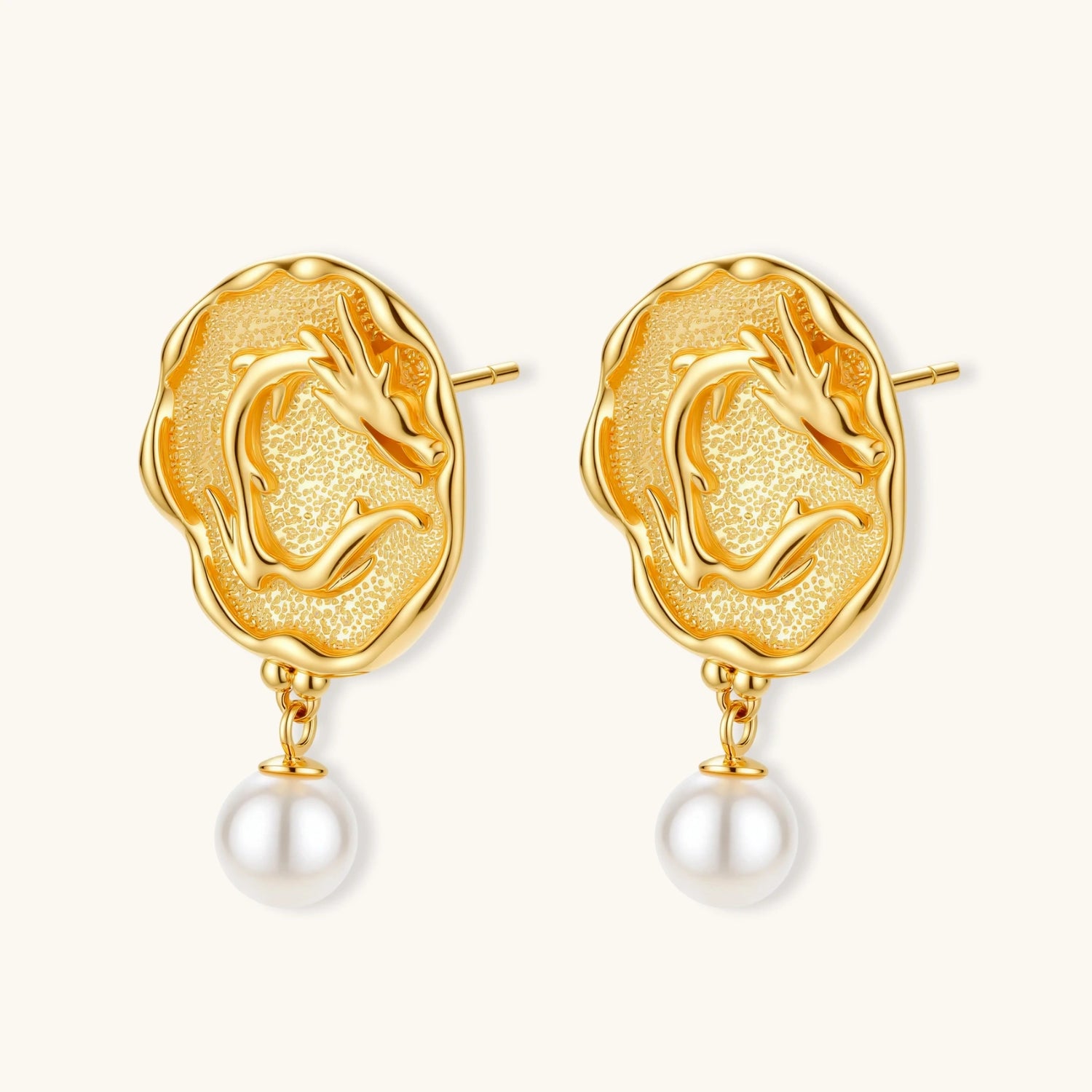 Ornate gold-plated dragon medallion earrings with white shell pearl drops on beige background, featuring detailed Chinese motifs.