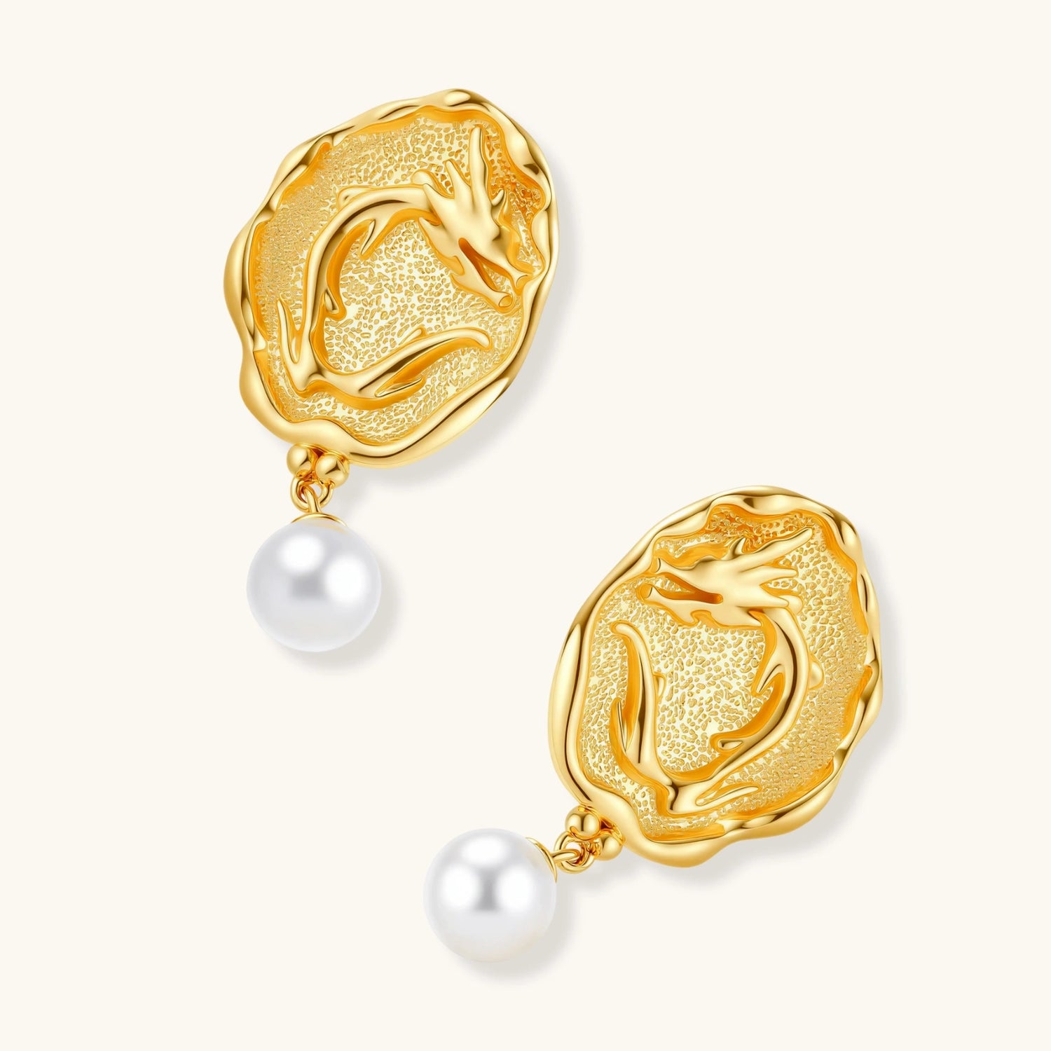Ornate gold-plated dragon medallion earrings with white shell pearl drops on beige background, featuring detailed Chinese motifs.