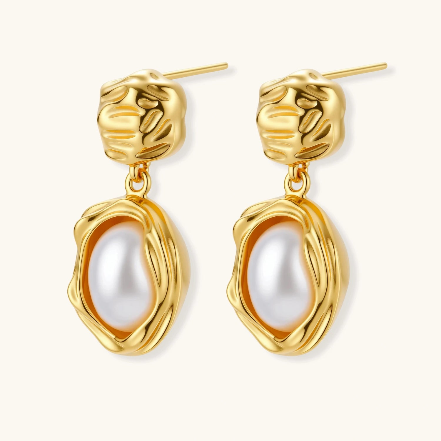 Gold-plated textured stud earrings with white freshwater pearl drops against cream background, showing organic rippled design