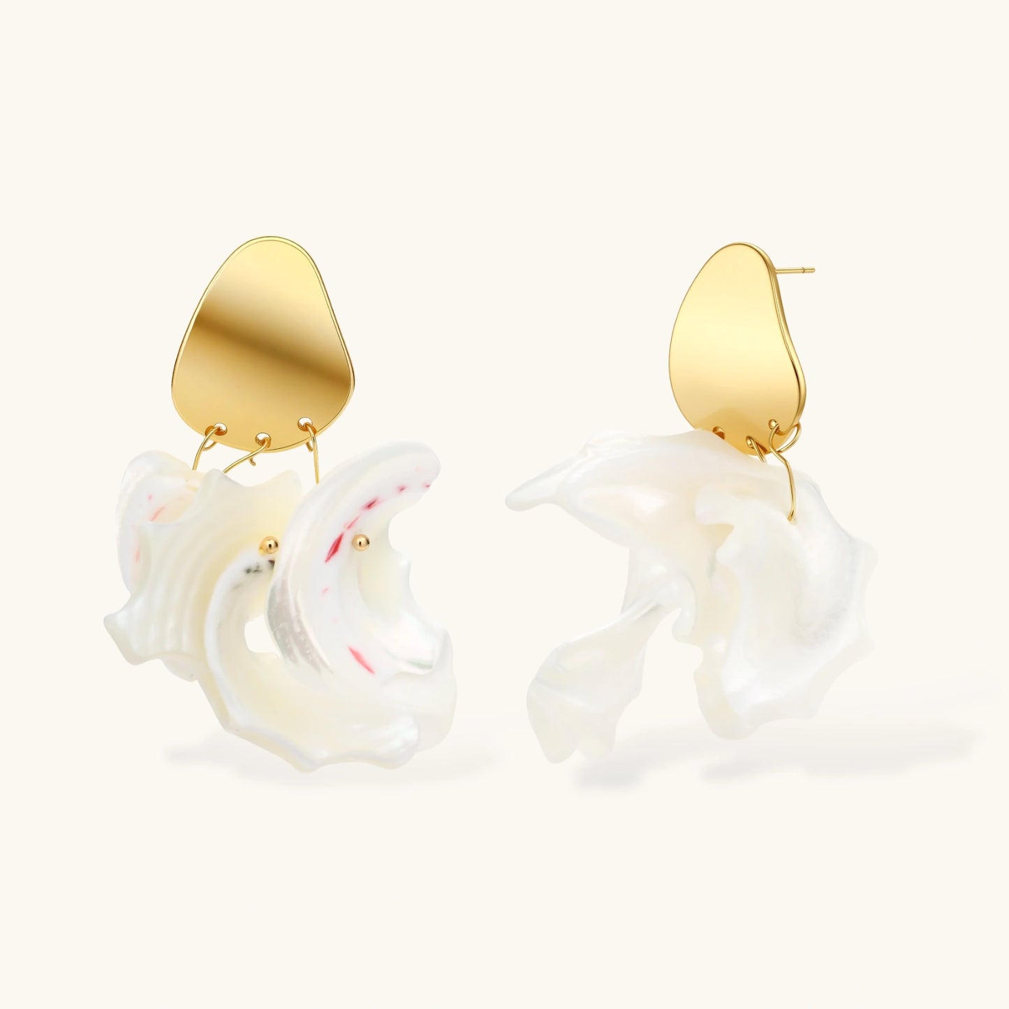 Gold-plated copper earrings with organic pebble studs and natural shell drops on cream background.