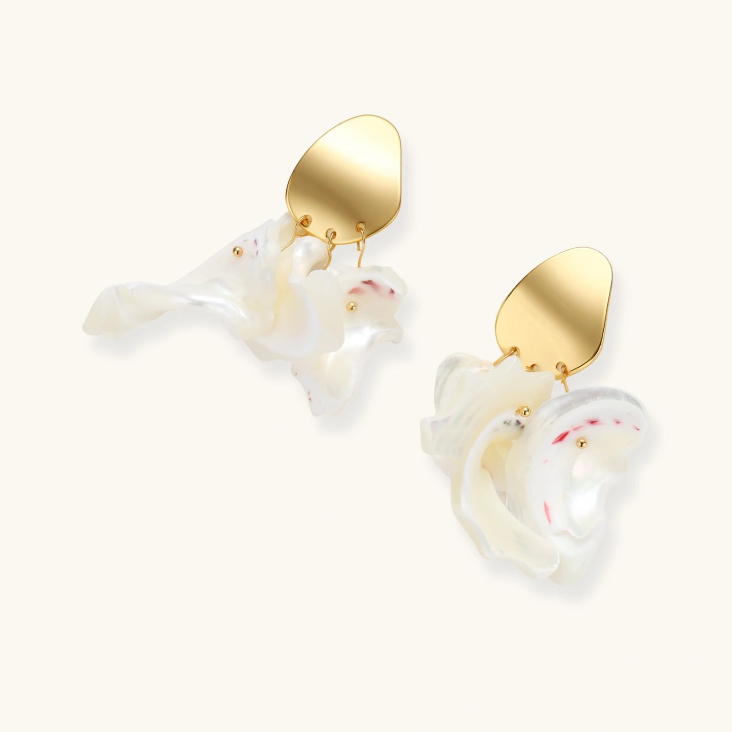 Gold-plated copper earrings with organic pebble studs and natural shell drops on cream background.