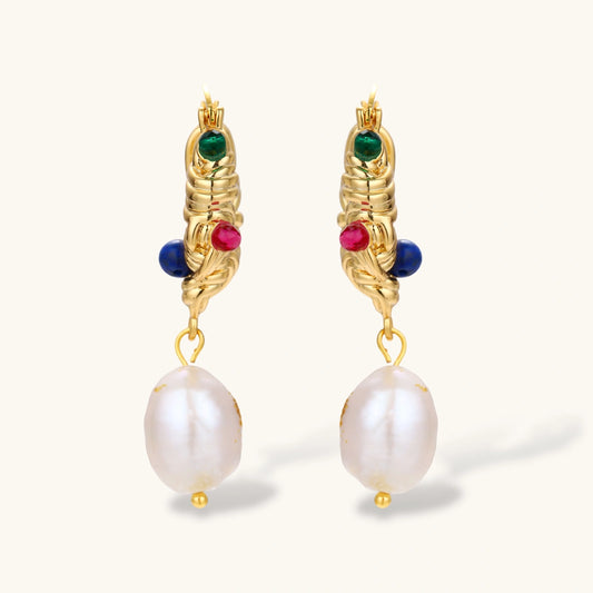 Ornate gold-plated hoop earrings with emerald, ruby, and sapphire accents, featuring dangling baroque freshwater pearls